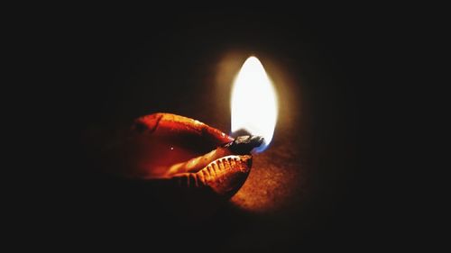 Close-up of lit candle in the dark