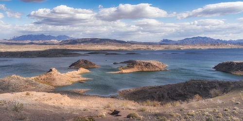 Scenic view of sea and mountains against sky