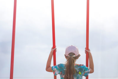 Rear view of woman swinging at playground