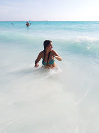 Girl bathes in the waves between the waters of the white beach of rosignano in tuscany