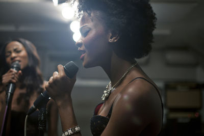 Young women singing in a recording studio