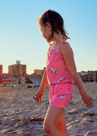 Young girl is playing with beach toys in the sand