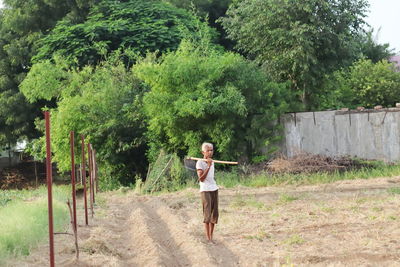 Full length of woman walking on street amidst trees