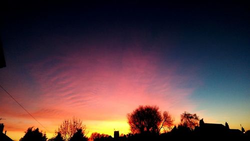 Low angle view of silhouette trees against sky at sunset