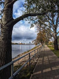 Footpath by railing against sky