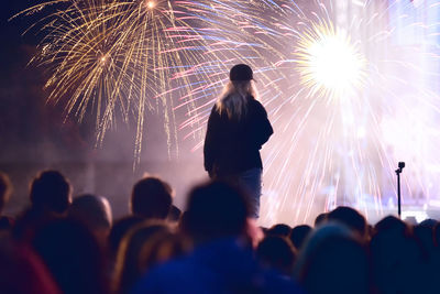 People watching firework display at night