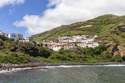 Scenic view of townscape by sea against sky