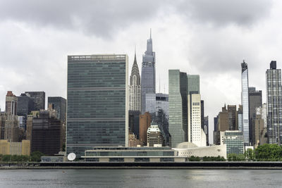 Modern buildings in city against cloudy sky