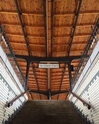 Low angle view of staircase with signboard at railroad station