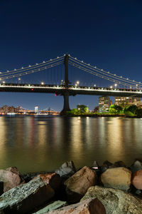 Suspension bridge over river at night