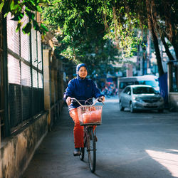 Portrait of woman cycling on street