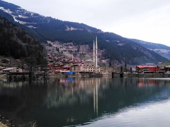 Scenic view of lake by buildings against sky