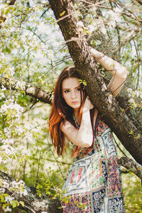 Portrait of young woman in tree