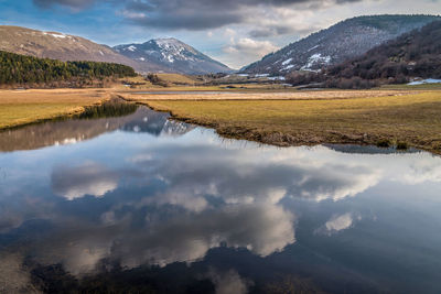 Scenic view of lake and mountains against sky