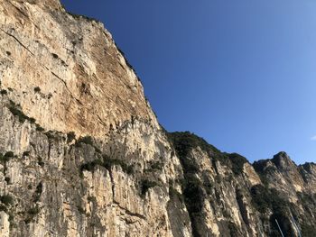 Low angle view of rock formation against clear blue sky