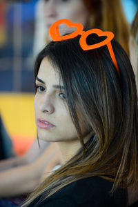 Young woman looking away while wearing red novelty glasses