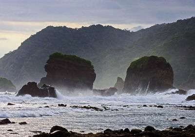 Scenic view of sea and mountains against sky