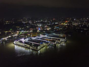 High angle view of illuminated buildings by river at night