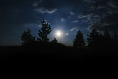 Silhouette trees on landscape against sky