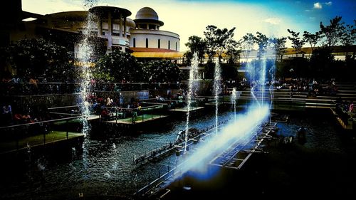 Fountain in city against sky