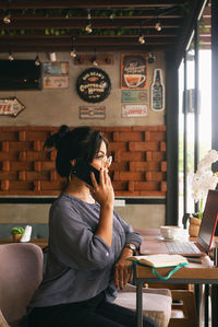 Woman talking on the phone, working and having coffee