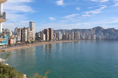 Buildings by sea against sky in city