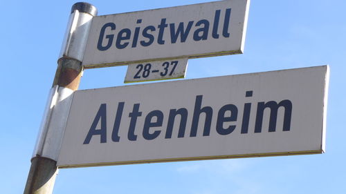 Low angle view of road sign against sky