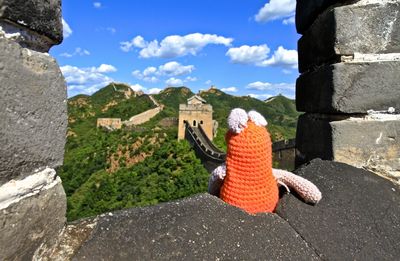Orange woolen toy at great wall of china against sky