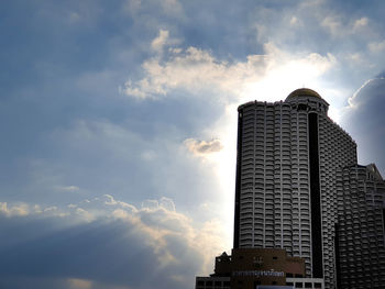 Low angle view of buildings against cloudy sky