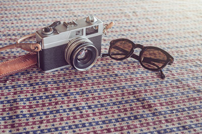 Close-up of camera and sunglasses on table