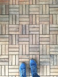 Low section of person standing on wooden floor