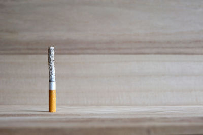 Close-up of burnt cigarette on wooden table