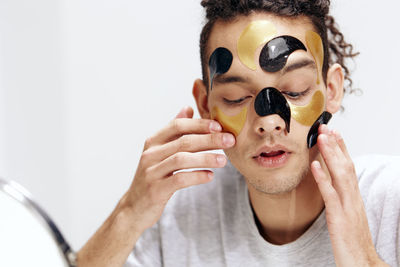 Portrait of young man applying face patches