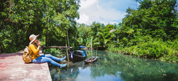 Rear view of woman sitting on boat in lake