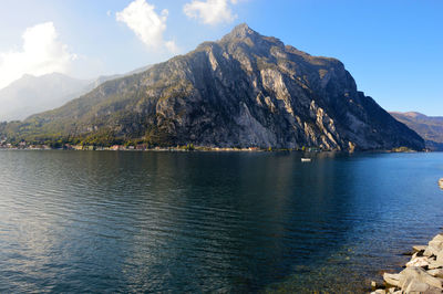 Scenic view of lake by mountains against sky