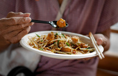 Midsection of man eating food