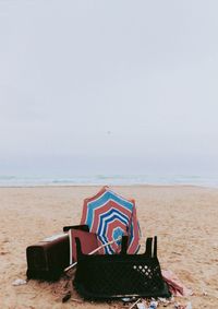 Deck chairs on beach against sky