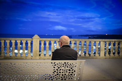 Rear view of woman sitting on chair