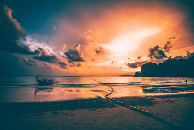 Scenic view of sea against dramatic sky during sunset