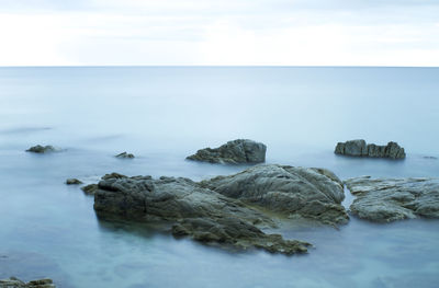 Rocks in sea against sky