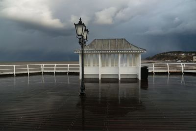 Built structure on pier by sea against sky