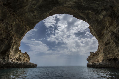 Scenic view of sea and rock formation against sky