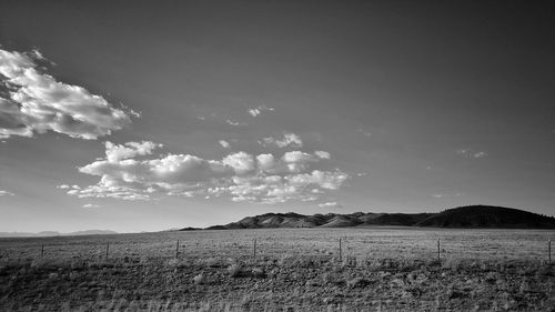 Scenic view of field against cloudy sky