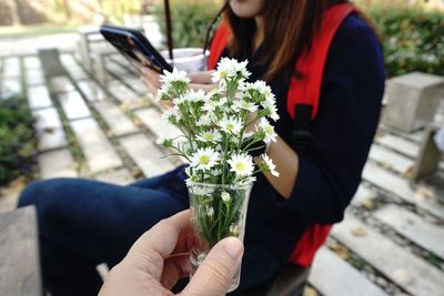 Midsection of woman holding flower bouquet