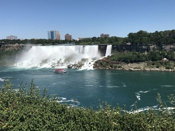 Scenic view of river against buildings in city