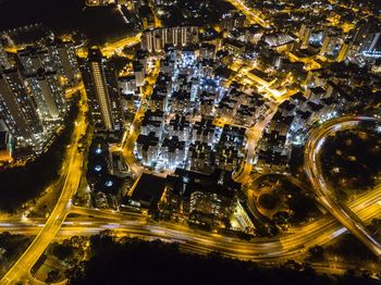 High angle view of illuminated street amidst buildings at night