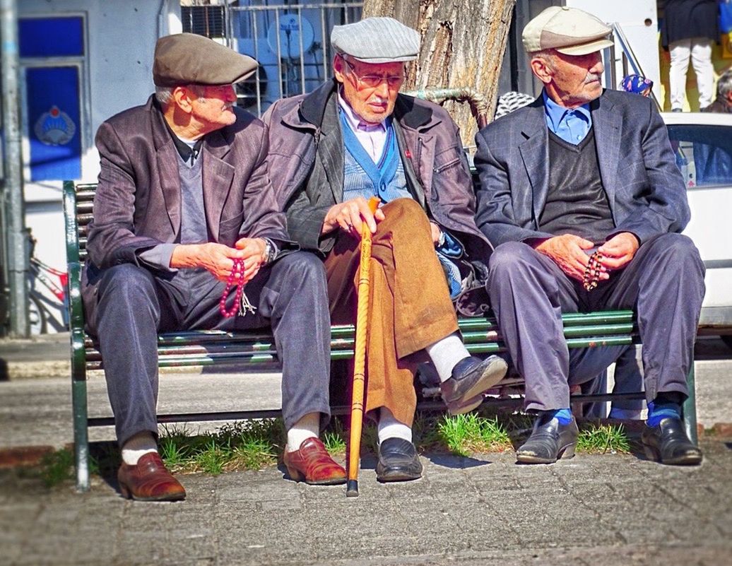 togetherness, men, lifestyles, casual clothing, person, sitting, leisure activity, full length, bonding, friendship, rear view, standing, love, medium group of people, city life, street