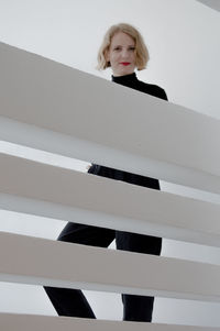 Portrait of young woman with hands on white background