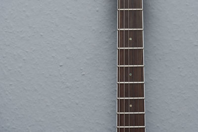 Close-up of guitar against wall