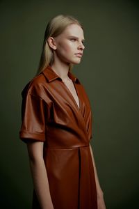 Young woman standing against wall